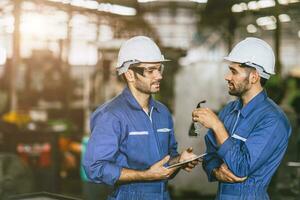 engineer worker male hispanic indian male teamwork happy working together in heavy metal industry steel lathe CNC factory photo