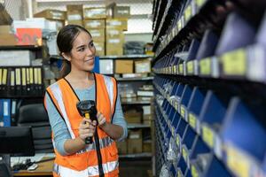 happy woman worker engineer technician staff work in factory products parts inventory warehouse storage using barcode scanner to check count part list photo