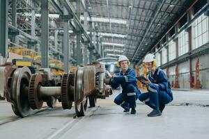 Engineer team working maintenance service fix replace train wheel in locomotive train repair depot. photo