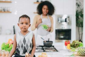 happy african black young mother with her boy lovely cute cooking together at home holiday activity photo