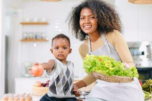 African black mother with cute son child portrait happy enjoy healthy food cooking at home kitchen holiday activity photo