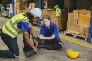 young woman warehouse worker accident leg injury slip and fall ankle sprain friend help support photo