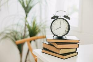 old bell clock on stack books, times for learning reading education remind concept. photo