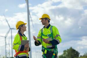 Wind turbines technician service teamwork talking together. Engineer team consulting team planing maintenance with lead project supervisor photo