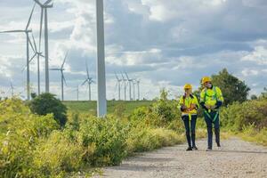 Engineers service team walking together working service maintenance wind turbine farm photo