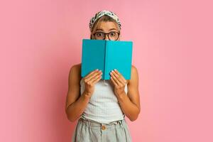 Studio photo of pretty blond  student woman with suprice face posing with note book on pink background.