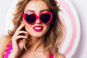 Pretty girl in sunglasses with beautiful skin and lips, posing in studio photo