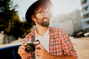 Exited man with beard with interesting using retro film camera , making photos. Tourist mane walking in big modern city. photo