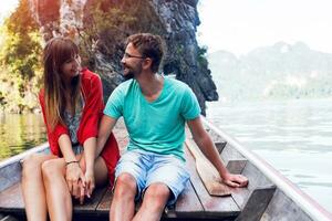 Traveling  couple in love  hugging and relaxing on longtail boat in thai island lagoon. Pretty woman and her handsome  man spending vacation time together . Happy mood. Adventure time. photo