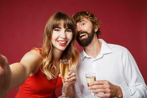 Elegant couple in love posing on red background in fashionable elegant outfit.  New Year mood photo