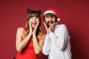 elegante Pareja en amor posando en rojo antecedentes en de moda elegante atuendo. nuevo año estado animico foto