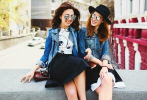 Lifestyle image of  two young pretty friends girls having fun outdoor on the street. photo