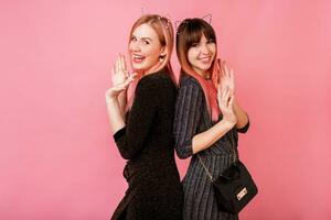 Best friends having fun together in studio on pink background photo