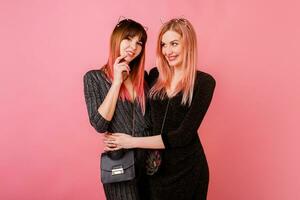 Best friends having fun together in studio on pink background photo