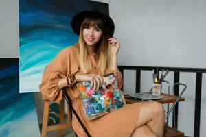 Woman artist in her art studio posing in linen dress. photo