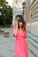 pretty romantic woman in pink dress posing outdoor in old european ity. photo