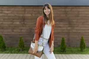 Beautiful smiling  woman in jacket posing  in the city. photo