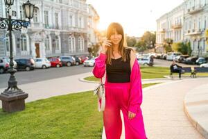 Pretty woman in stylish casual outfit  posing  in old european city. Warm sunset color. Summer mood. photo