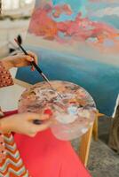 hembra artista pintura en lona en su Arte estudio. vistiendo elegante boho atuendo. foto