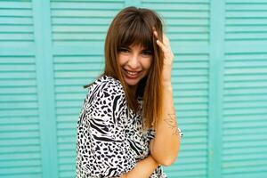 Outdoor portrait of pretty woman posing  over blue wall. photo