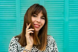 Close up portrait of pretty woman posing  over blue wall. photo