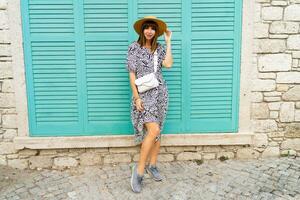 Outdoor portrait of pretty woman posing  over blue wall. photo