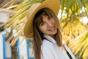 verano retrato de bonito morena mujer en Paja sombrero posando exterior. foto