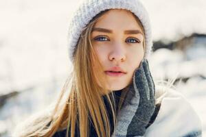 Winter lifestyle portrait of young blonde fresh lady in warm wool  fluffy  scarf in park. photo