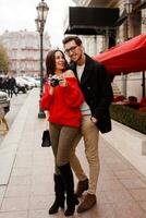 Full height outdoor image of fashionable elegant couple in love walking on the street during date or holidays. photo