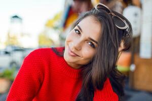 Close up portrait of  elegant romantic woman with brunette wavy hairs with stylish  retro sunglasses and wed knitted sweater. Female chilling  in modern cafe in the morning and drink coffee. photo