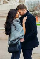 joven Moda Pareja posando en el antiguo calle en soleado otoño . bonito hermosa mujer y su hermoso elegante novio abrazando en el calle. cremoso otoño luz de sol. foto