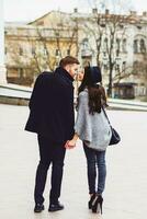 joven Moda Pareja posando en el antiguo calle en soleado otoño . bonito hermosa mujer y su hermoso elegante novio abrazando en el calle. cremoso otoño luz de sol. foto