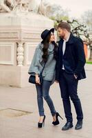 Young fashion couple posing on the old  street in  sunny fall . Pretty beautiful  woman and her  handsome stylish boyfriend  hugging  on the street. Creamy  autumn sunlight. photo