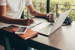 Handsome hipster man with beard using lap top at home photo