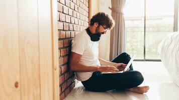 Handsome hipster man with beard using lap top at home photo