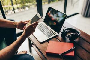 Handsome hipster man with beard using lap top at home photo