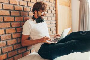 Handsome hipster man with beard using lap top at home photo