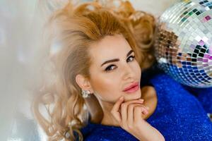 Studio photo of shiny blond woman in sexy pink dress. Perfect wavy hairs. New year  party.