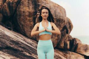 Graceful woman practice yoga  on rocks. photo