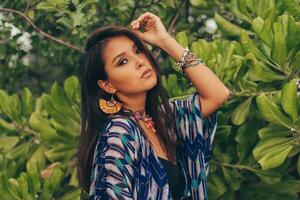 Close up portrait of beautiful asian woman in tropical outfit posing on the beach. photo