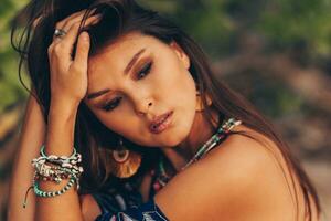 Close up portrait of beautiful asian woman in tropical outfit posing on the beach. photo