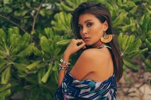 Close up portrait of beautiful asian woman in tropical outfit posing on the beach. photo