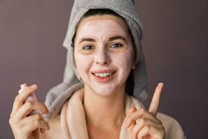 piel cuidado. mujer utilizando máscara a su rostro. el niña toma cuidado de aceitoso piel. cosmético procedimientos. foto