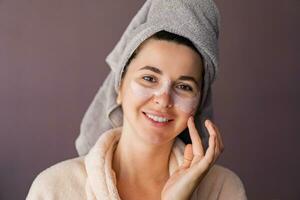 piel cuidado. mujer utilizando máscara a su rostro. el niña toma cuidado de aceitoso piel. cosmético procedimientos. foto