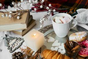 Still life with delicious Christmas gingerbread and cookies  breakfast on a tray in bed , donuts and croissants , cup of cacao or latte with cinnamon, ginger biscuits figure, Christmas candles. photo