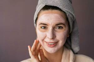 piel cuidado. mujer utilizando máscara a su rostro. el niña toma cuidado de aceitoso piel. cosmético procedimientos. foto