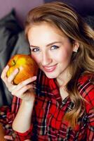 cerca arriba retrato de joven Fresco atractivo rubia mujer en tartán camisa posando . tener grande azul ojos y llenar labios. foto