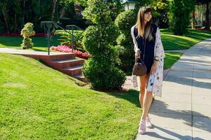 Amazing stylish  woman in blue playsuit  and white kimono enjoying vacation. She is smiling, showing signs. photo