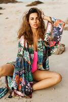 Close up portrait of beautiful brunette  woman in sexy swimwear posing on the beach in sunset light. Pertfect wavy hairs, tan skim body. Summer tropical mood. photo