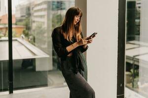 Stylish business woman in fashionable casual outfit  talking by mobyle phone  during work day in  modern business center. photo